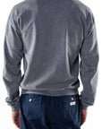 Back view of a person wearing a gray sweatshirt and navy day pants on a white background