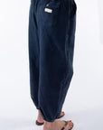 Side view of a woman wearing navy day pants on a white background