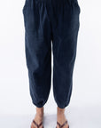 Woman wearing navy day pants on a white background