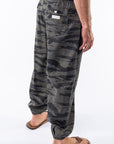 Side back view of ocean tiger camo day pants worn by a person on a white background.