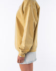 Side view of a woman wearing a yellow oversized sweatshirt and a denim mini skirt on a white background