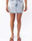 Woman wearing a light blue denim mini skirt on a white background