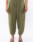 Woman wearing army green day pants on a white background