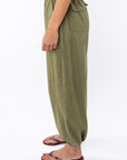 Side shot of a woman wearing army green day pants on a white background