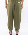 Back shot of a woman wearing army green day pants on a white background