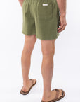 Side back view of army green day shorts worn by a person on a white background