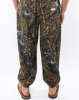 Back view of real tree camouflage day pants worn by a person on a white background