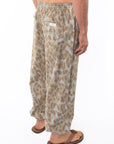 Side back shot of a man wearing Leopard Camo day pants.