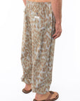 Side back shot of a man wearing Leopard Camo day pants.