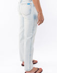 Back side view of a woman wearing light denim washed jeans on a white background