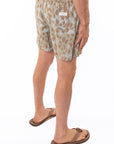 Side back view of a man wearing leopard camo printed day shorts on a white background