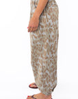 Side shot of a woman wearing Leopard printed pants on a white background.