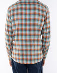 Back shot of man wearing a lightweight flannel Plaid shirt in Green/Orange with navy pants on a white background.