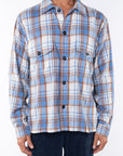 Man wearing Bucky Flannel Over shirt in Blue/Tan with navy day pants.
