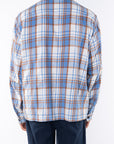 Back shot of a man wearing Bucky Flannel Over shirt in Blue/Tan with navy day pants.