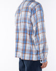 Side back shot of man wearing Bucky Flannel Over shirt in Blue/Tan with navy day pants.