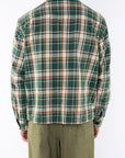 Back shot of a man wearing Bucky Flannel Over shirt in Green/Brown with army green day pants