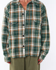 Woman wearing the Bucky Flannel Over shirt in green/brown with Surf Tank in Sandstone and army green day pants.