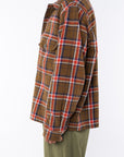 Side shot of a woman wearing Bucky Flannel Over shirt in Brown/Red with army green day pants