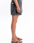 Side view of a woman wearing gray french terry day shorts on a white background