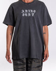 Person wearing a black graphic t-shirt with 'ARIKO SURF' logo text on a white background