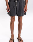 Person wearing dark gray french terry day shorts on a white background