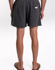 Back view of a person wearing dark gray french terry day shorts on a white background