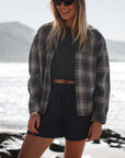 woman wearing summer softy plaid shirt in black/red with beach crop t-shirt and navy day shorts