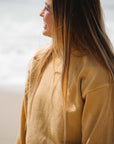 close shot of woman wearing the post surf crew sweatshirt in sunrise yellow