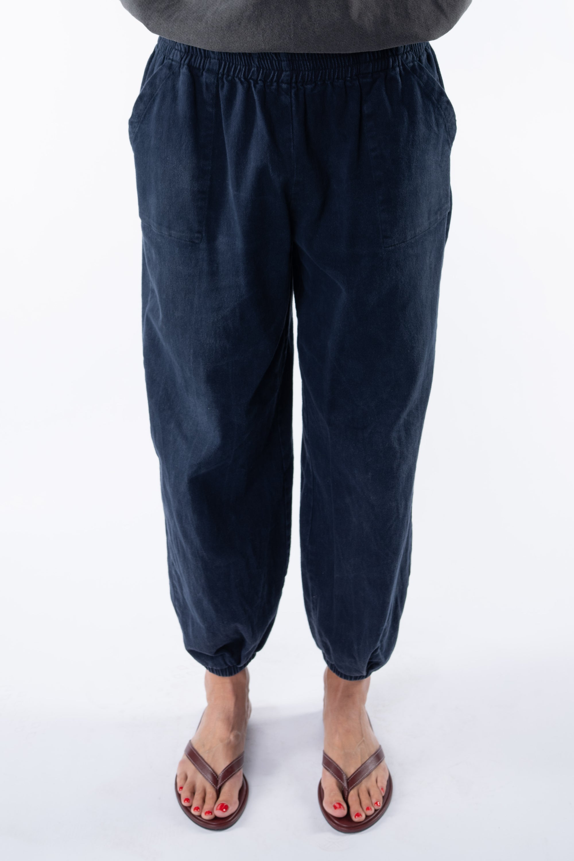 Woman wearing navy day pants on a white background