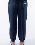 Back view of a woman wearing navy day pants on a white background