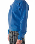 Side front view of a person wearing a blue wave sweatshirt on a white background