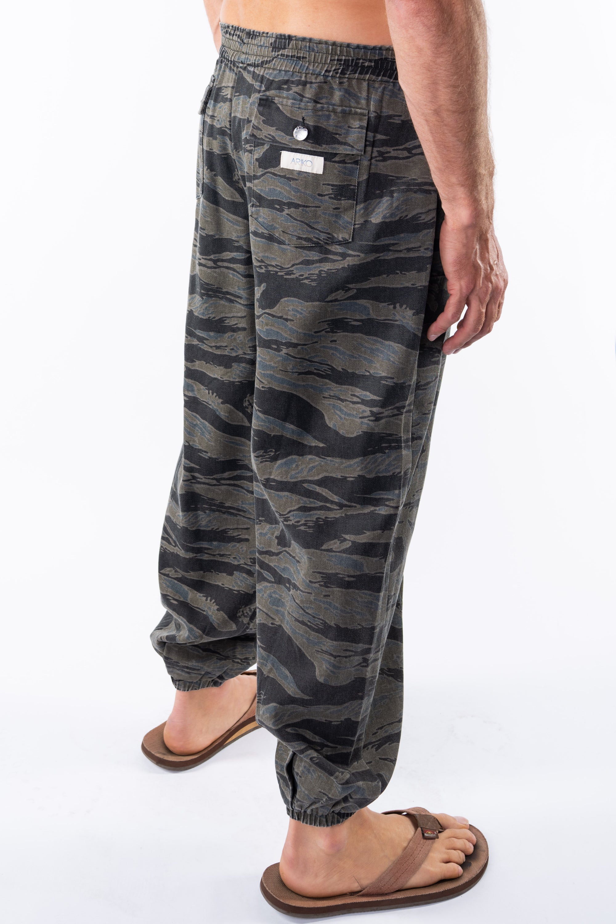 Side back view of ocean tiger camo day pants worn by a person on a white background. 