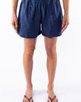 Woman wearing navy blue day shorts on a white background