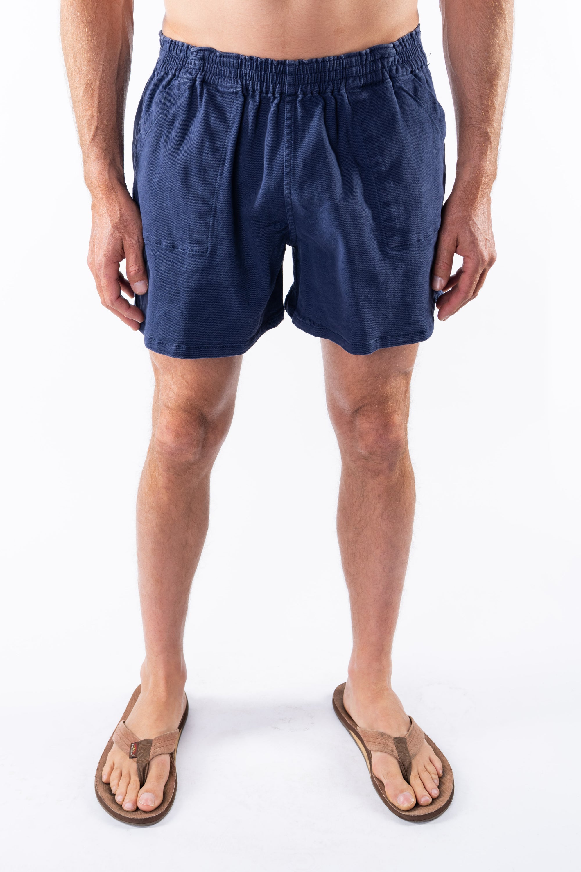 Person wearing navy blue day shorts on a white background
