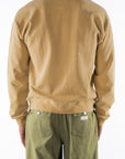 Back view of a person wearing a sunrise yellow sweatshirt and army green day pants on a white background