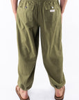 Back view of army green day pants worn by a person on a white background