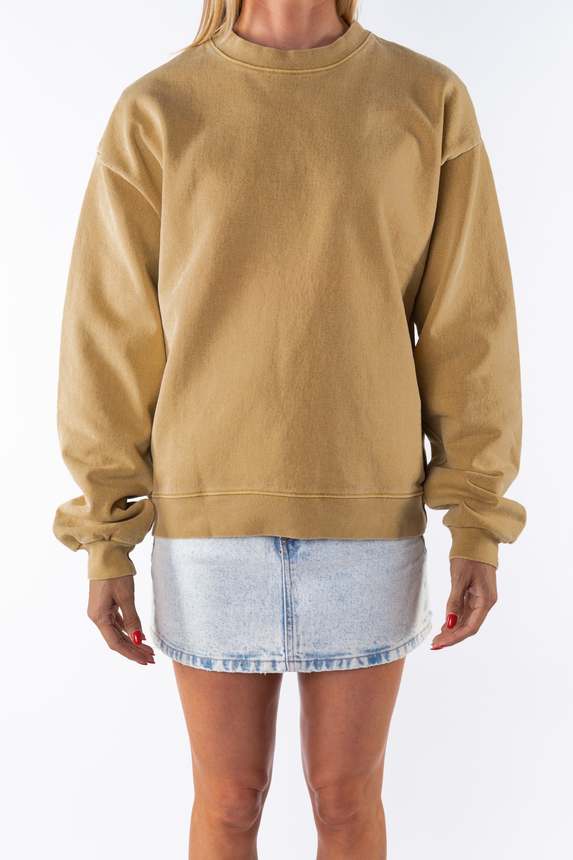 Woman wearing a sunrise yellow sweatshirt and denim mini skirt on a white background