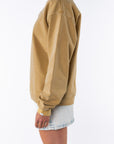 Side view of a woman wearing a sunrise yellow sweatshirt and denim mini skirt on a white background