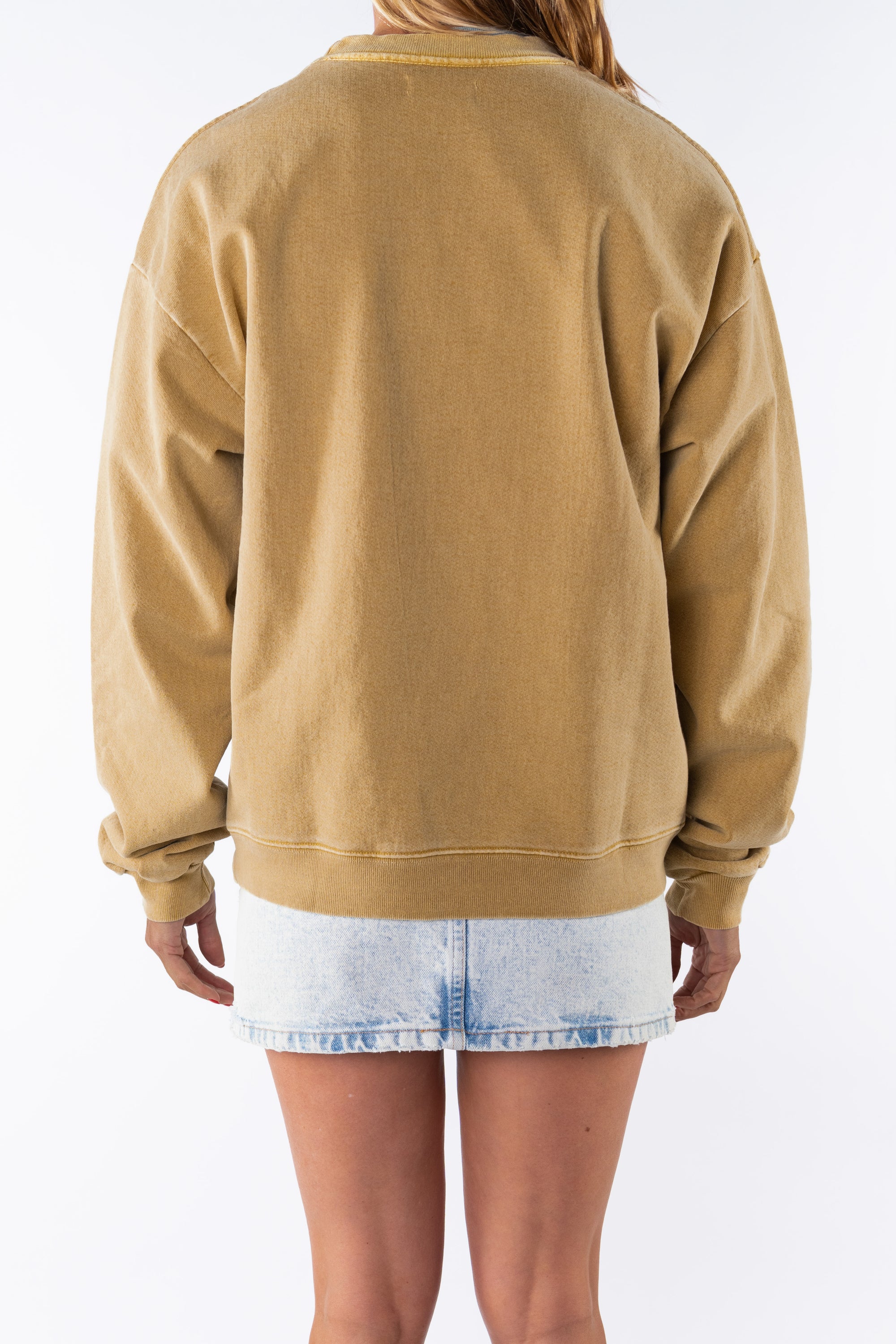 Back view of a woman wearing a sunrise yellow sweatshirt and denim mini skirt on a white background