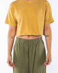Woman wearing a Crop T-shirt in yellow and army green pants on a white background