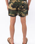 Back view of camouflage day shorts worn by a person on a white background