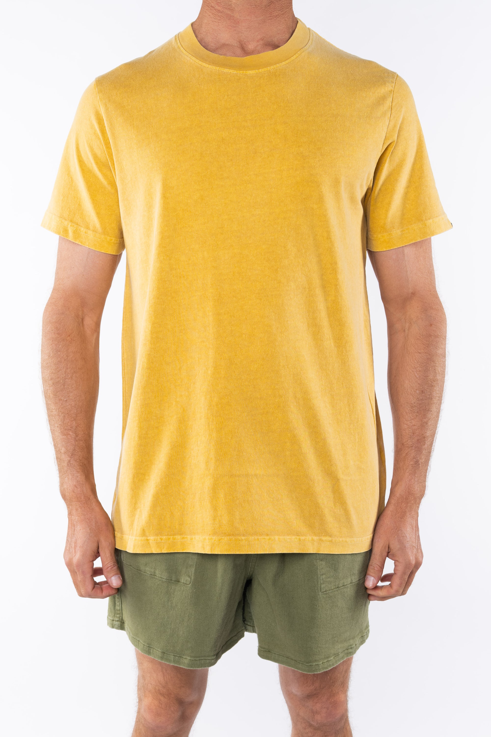 Person wearing a sunrise yellow beach t-shirt and army green day shorts on a white background