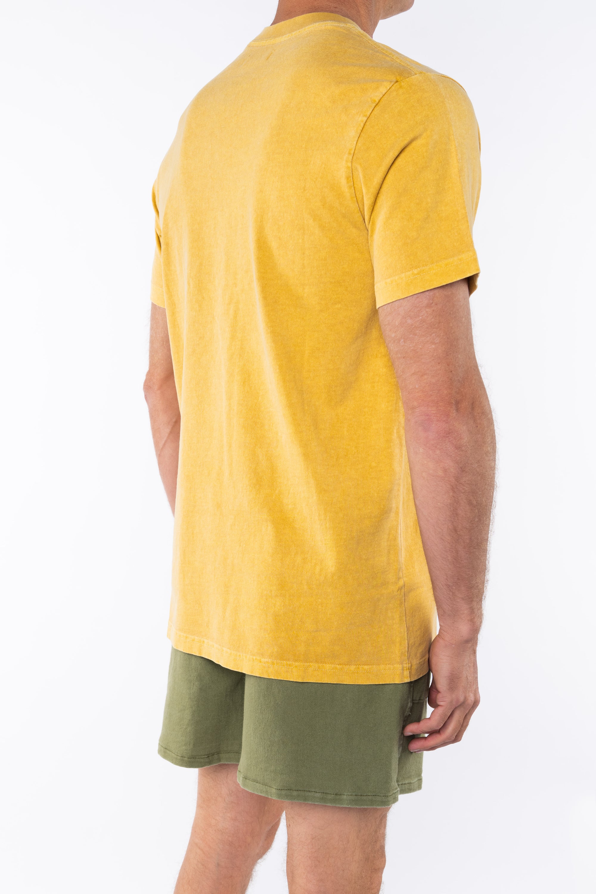 Side back view of a person wearing a sunrise yellow beach t-shirt and army green day shorts on a white background