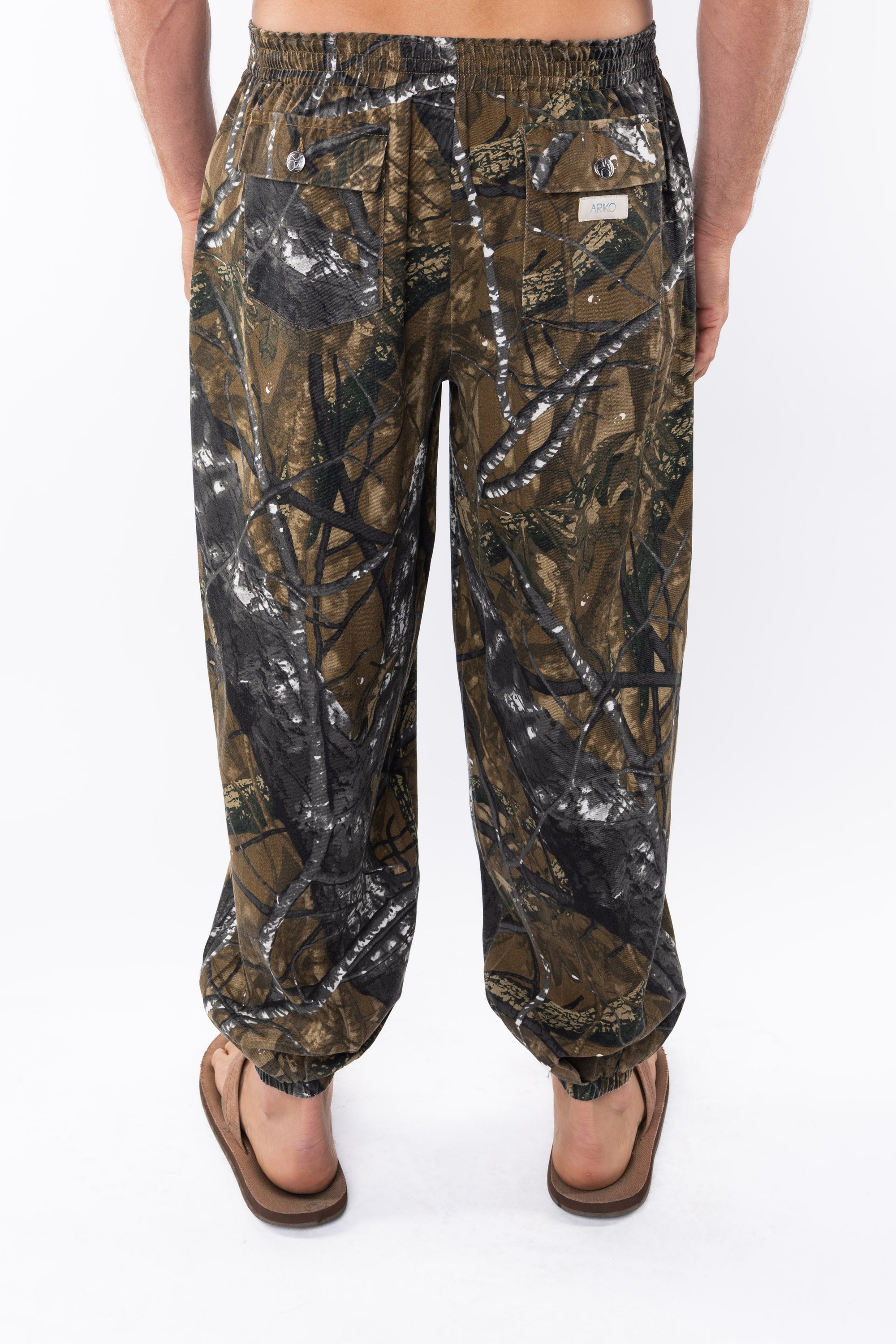 Back view of real tree camouflage day pants worn by a person on a white background