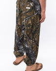 Side back view of real tree camouflage day pants worn by a person on a white background