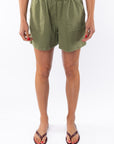 Woman wearing army green day shorts on a white background