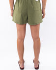Woman wearing army green day shorts on a white background