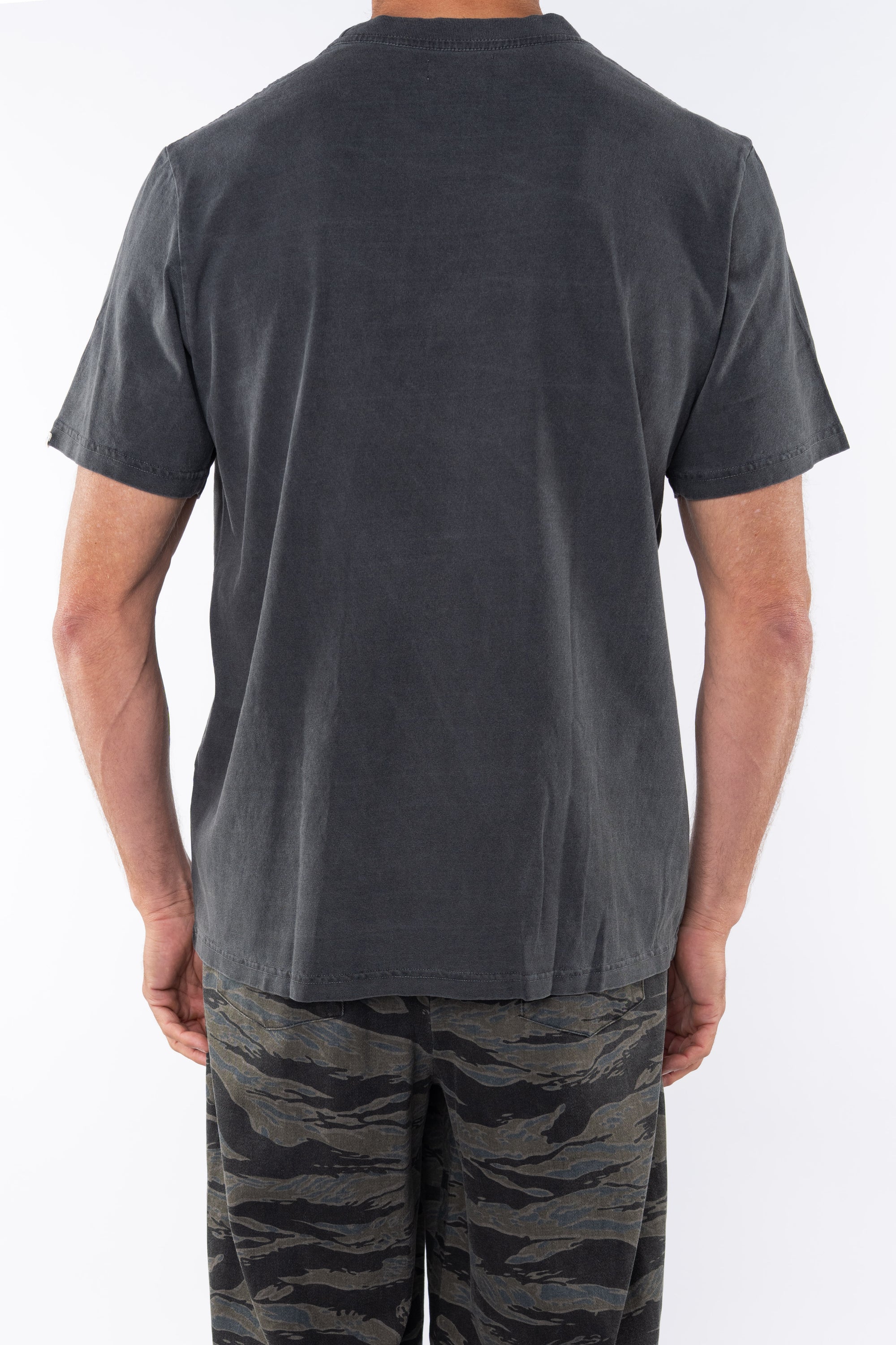 Back shot of a man wearing Beach Crewneck T-shirt in Sea Gray with Ocean Tiger Camo day pants.
