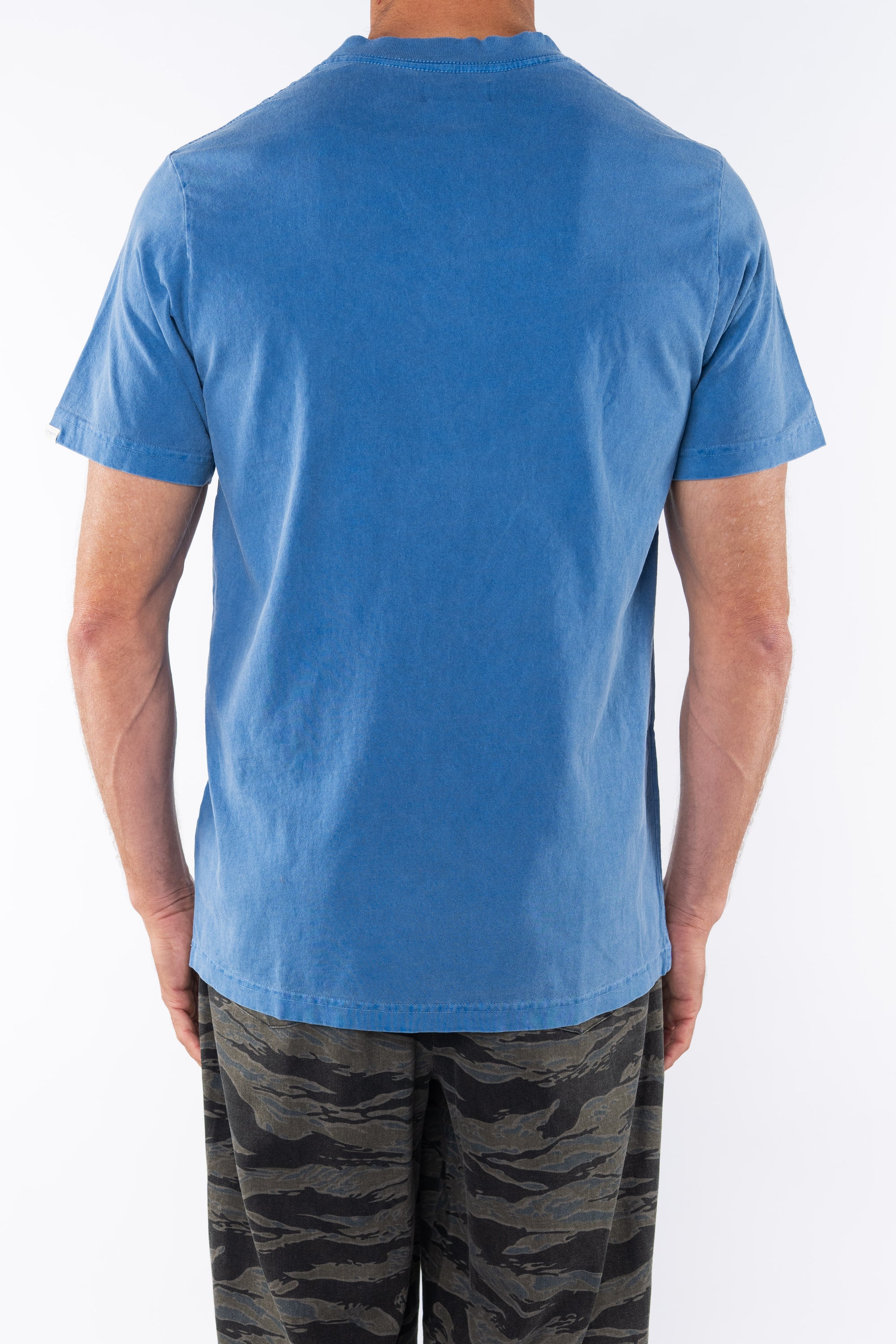 Back shot of a man wearing Beach Crewneck T-shirt in Blue Wave with Ocean Tiger Camo day pants.